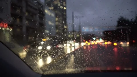 Raindrops on windscreen of a moving car with bokeh background at late afternoon Stock Footage 71777878