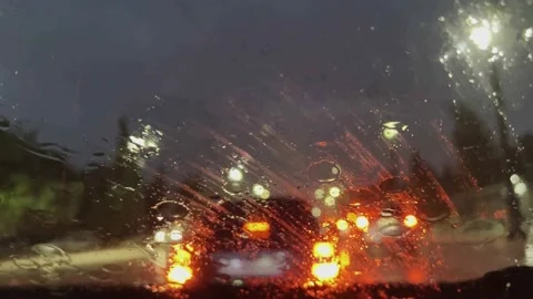 Raindrops on the windshield of the car. The car is driving through the streets. Stock-Footage 202606552
