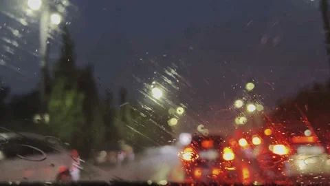 Raindrops on the windshield of the car. The car is driving through the streets. Stock-Footage 202606600