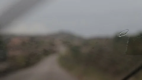 Raindrops on the windshield of the car in the suburbs of Cala Mendia Stock Footage 75961937