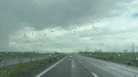 Raindrops on the windshield of a car while driving on a wet road Stock Footage 337359637