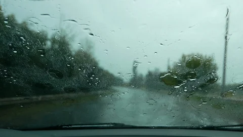Raindrops on the windshield. Driving in a car in rain downpour on a wet road  Stock Footage 93783554