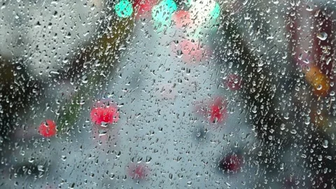 Raindrops on a windshield form bokeh from colorful city traffic lights Video stock 327322690