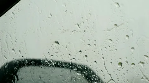 Raindrops on Windshield With Side Mirror in Background Stock Footage 346036948