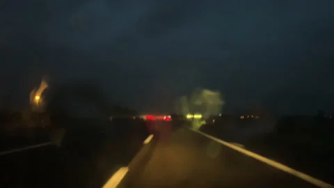 Raindrops on windshield while driving in a car at night.  Poor visibility 스톡 동영상 141183542