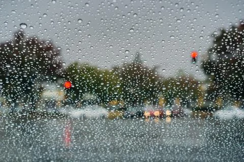 Raindrops on the windshield while waiting at a traffic junction on a rainy .. Stock Photos