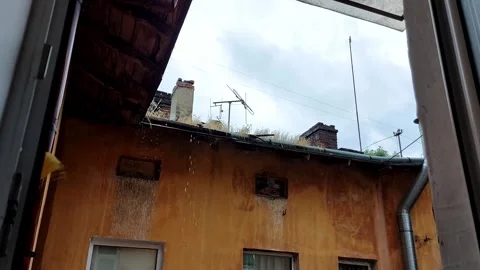 Rainfall over Rooftop Seen Through Window: Urban Stillness in Motion Stock Footage 313920845