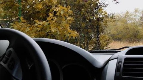 Rainfall pour through transparent windshield with defocused background of yellow Stock Photos