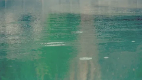 Rainfall in slow motion over blue water Stock Footage 101122200