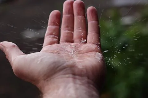 Rainfall splashing on a hand Stock Photos