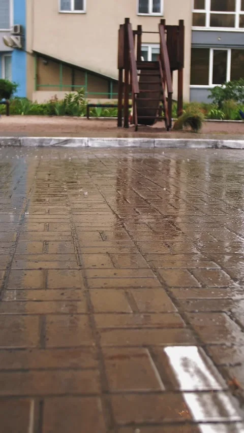 Raining. close-up. raindrops fall on wet street tiles against background of Stock Footage 311999032