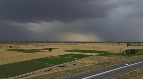 Raining clouds around the wheat crop adjacent to Motorway, Stock Photos