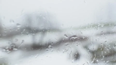 Raining on glass window with out of focus tree in winter Vidéo 259229573