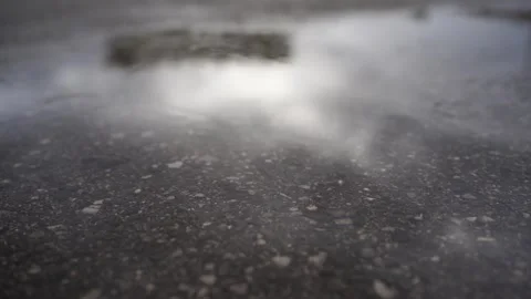 Raining leaving circles in a puddle on the pavement Stock Footage 276809431