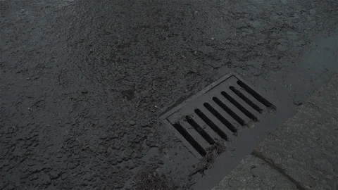 Raining over drain in road Stock Footage 93208540