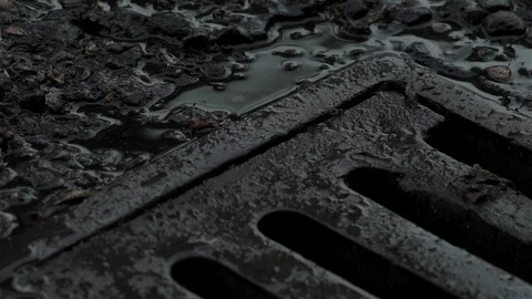 Raining over drain in road Stock Footage 93208612