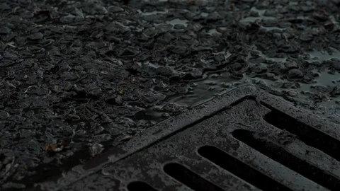 Raining over drain in road Stock Footage 93208624