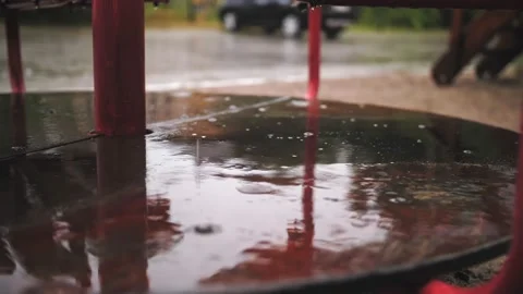 Raining on playground. close-up. raindrops fall into puddles, on wet, empty Video stock 159375964