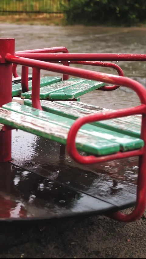 Raining on playground. close-up. Wet, empty merry go round carousel , in the Stock Footage 305701445