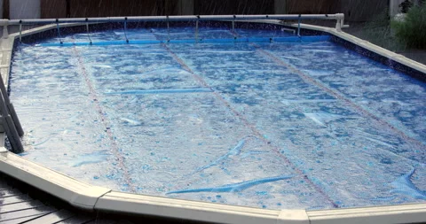 Raining on Pool while Solar Cover is On Stock Footage 253513049