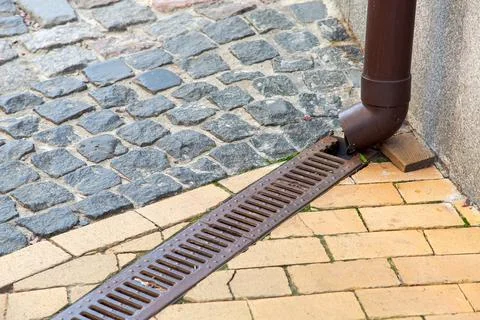 A rainwater drainage pipe system under a pedestrian pavement. Stock Photos