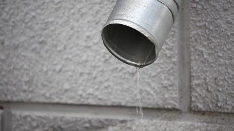 Rainwater drains from the drainpipe. The concept of gutters, snow melting Stock Footage 148284584