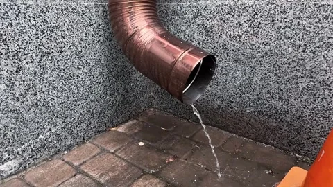 Rainwater dripping from a metal gutter pipe Stock Footage 335706989