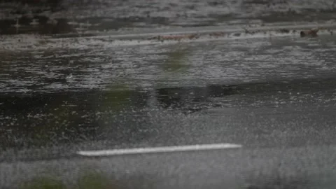 Rainwater drips down on the asphalt. Strong jets of rainwater flow down from the Stock Footage 192961456