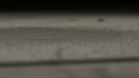 Rainwater Droplets Landing on Grey Concrete at Night Stock Footage 135007953