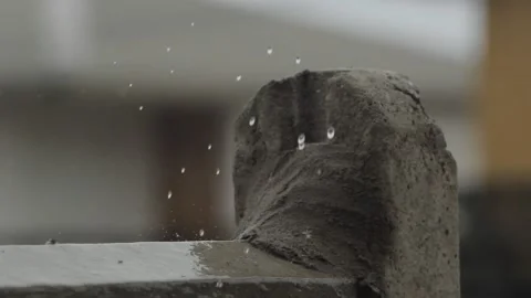 Rainwater drops falling on cement wall Stock Footage 233382070