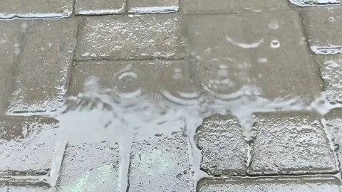 Rainwater falling on the paving blocks in the afternoon Stock Footage 285592561