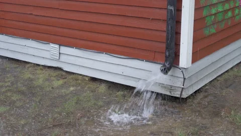 Rainwater flood through drainpipe on to the ground during heavy rain storm Stock Footage 158797254