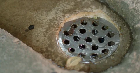 Rainwater flowing continuously into a drain pipe during wet weather. Stock Footage 316487254