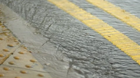 Rainwater flowing down edge of road Stock Footage 44055406