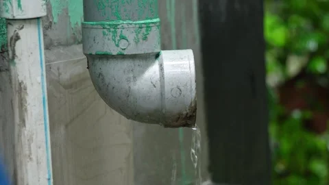 Rainwater Flowing Out of Plastic Gutter Downspout Pipe Exterior Footage. Stock Footage 338030282