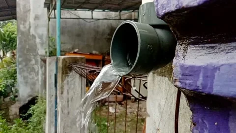 Rainwater flowing from the pipe to the drain. Stock Footage 322985770