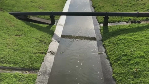 Rainwater flowing under a drainage pipe Video stock 174165273