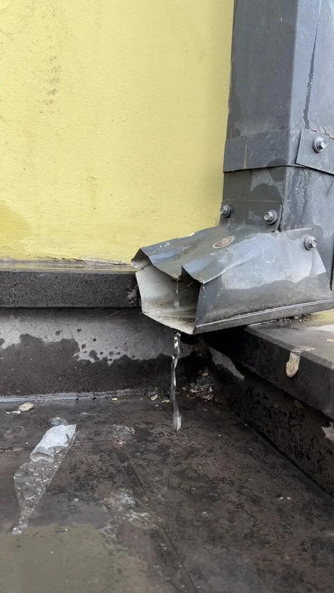 Rainwater flows down on asphalt of sidewalk from metal drain pipe Stock Footage 272280196
