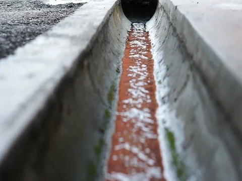 Rainwater flows in the drain. Selective focus Stock Footage 83963175
