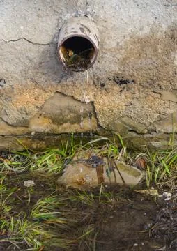 Rainwater flows from a rain gutter at a house Stock Photos