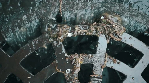 Rainwater flows on the road and fall into the metal hatch with holes drain  Stock Footage 64701490