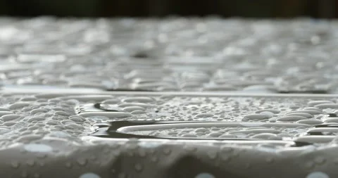 Rainwater on a patterned tablecloth on an outside table. Stock Footage 240367287