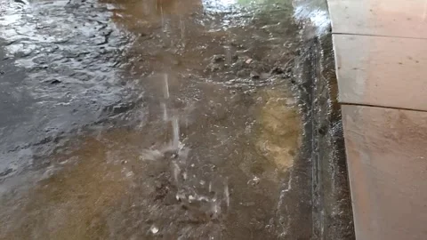 Rainwater Splashes Onto Concrete Surface During a Heavy Downpour Stock Footage 304431838