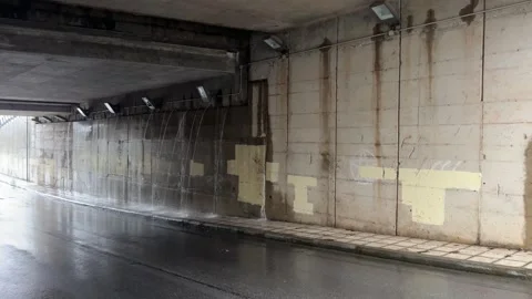 Rainwater trickle on urban underpass wall during overcast daytime Stock Footage 325519067