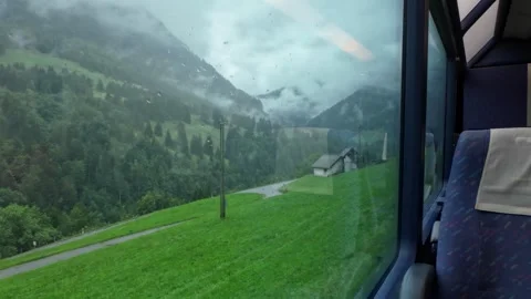 Rainy Alpine Landscape Seen from a Train Window Stock Footage 328129730