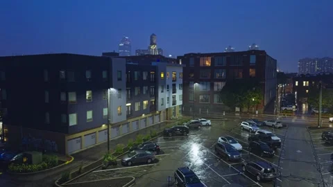 Rainy Apartment Complex and Parking Area with Storm Reflections at Dusk Stock Footage 338013663