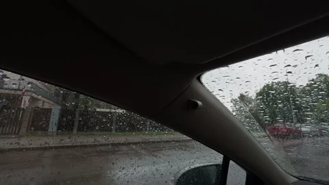 Rainy car interior view through windshield with water droplets, street buildings Stock Footage 345128788