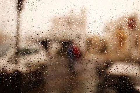 Rainy city background. Raindrops on window glass on autumn day. Wet home wind Stock Photos
