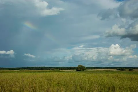 Rainy clouds in the sky with a rainbow Stock Photos