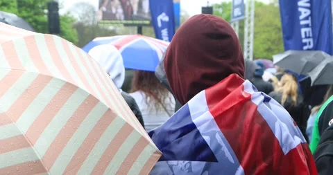 Rainy crowd watching Charles III coronation on big screen, Union Jack Stock Footage 321017150